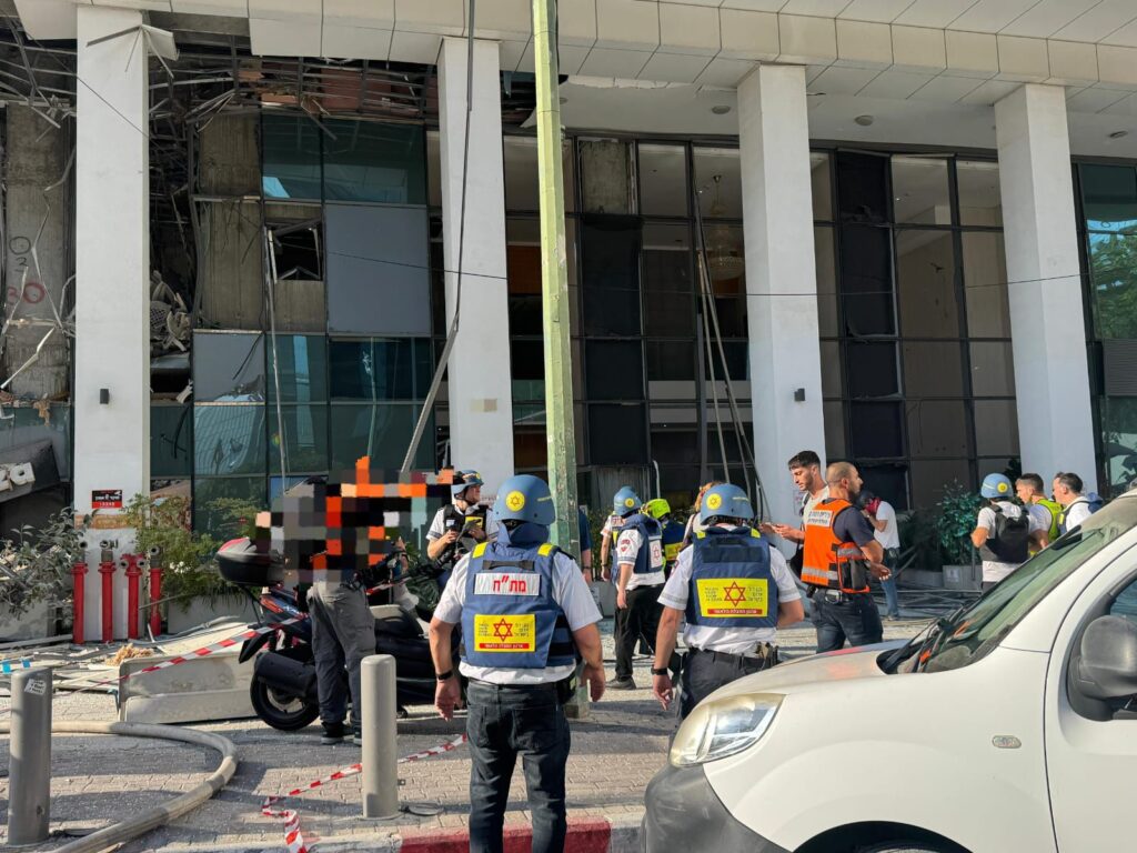 צוותי חילוץ מול בניין שנפגע עם לכודים