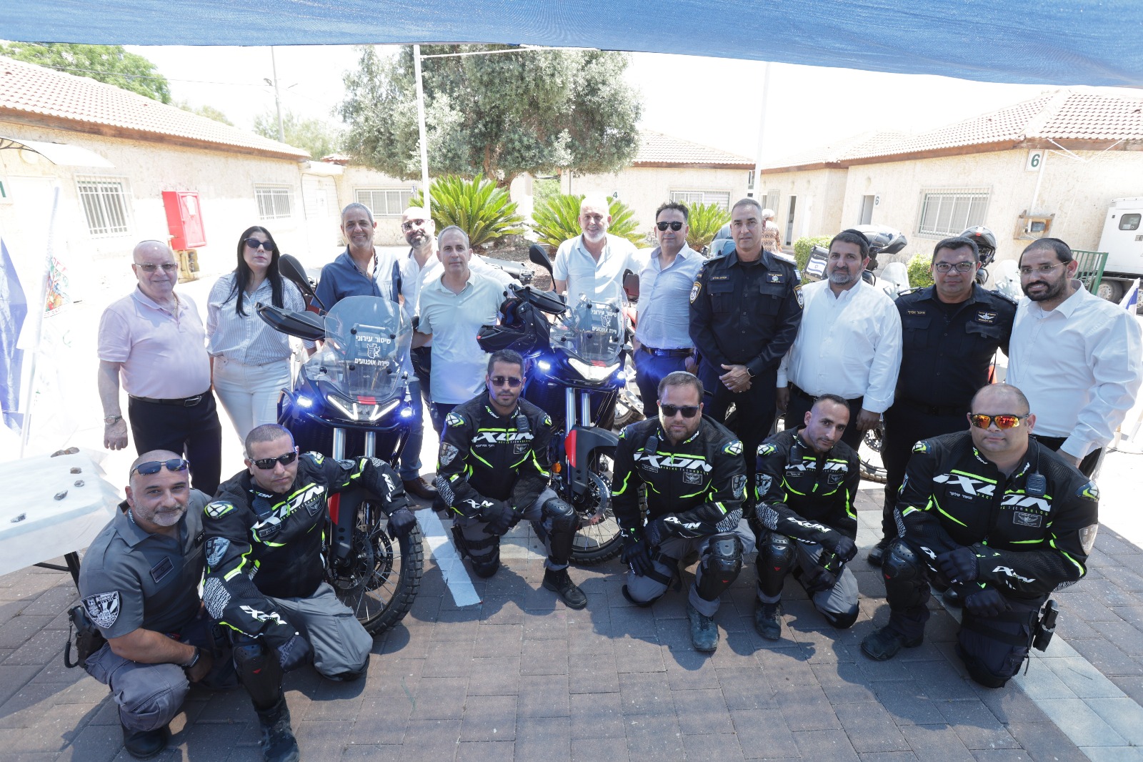 תמונה של פקחים ועובדי עירייה לצד האופנועים