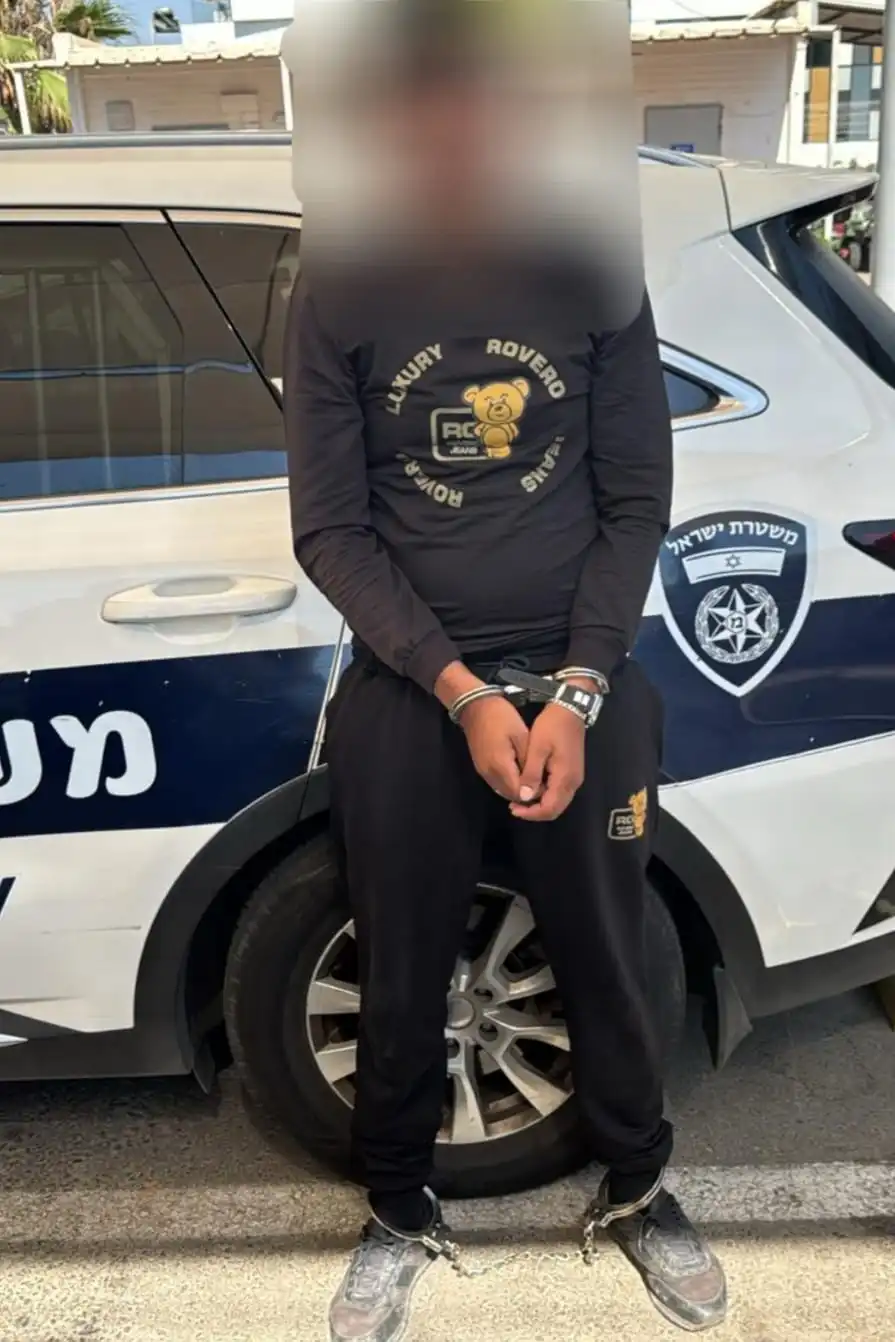 צילום החשוד עם ידיים כפותות לאחר המעצר