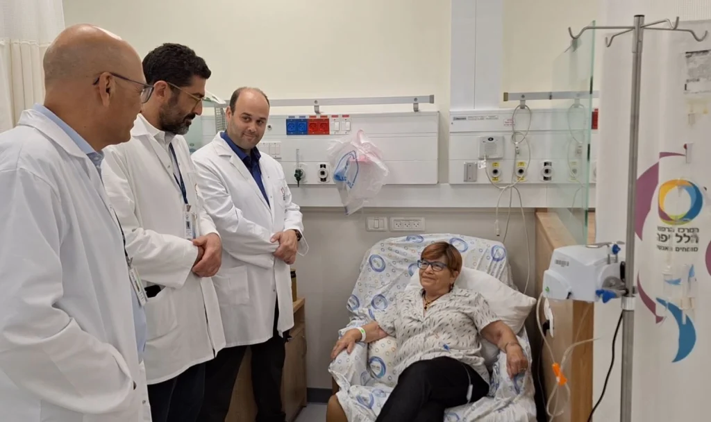 צילום של המטופלת לצד הרופאים בחדר טיפול בבית החולים