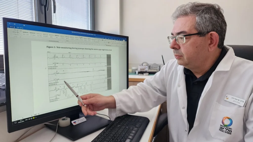 תמונה של הקרדיולוג מצביע על הקו הישר במדדי פעילות הלב של החולה