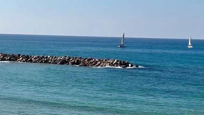 צילום של שובר גלים עם מפרשיות בחוף נתניה