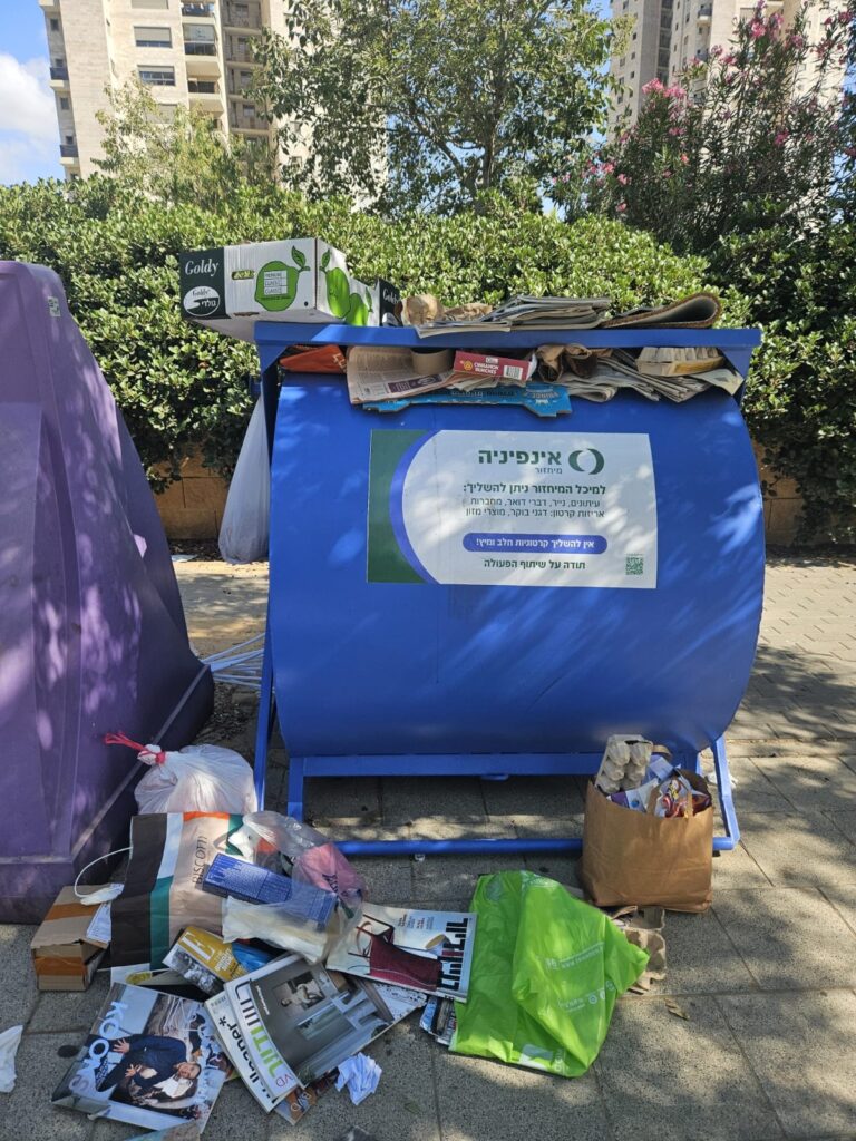צילום של פח מיחזור נייר שעולה על גדותיו