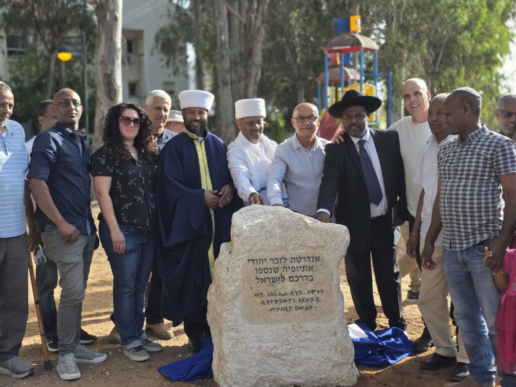 צילום מכובדי העדה לצד האנדרטה