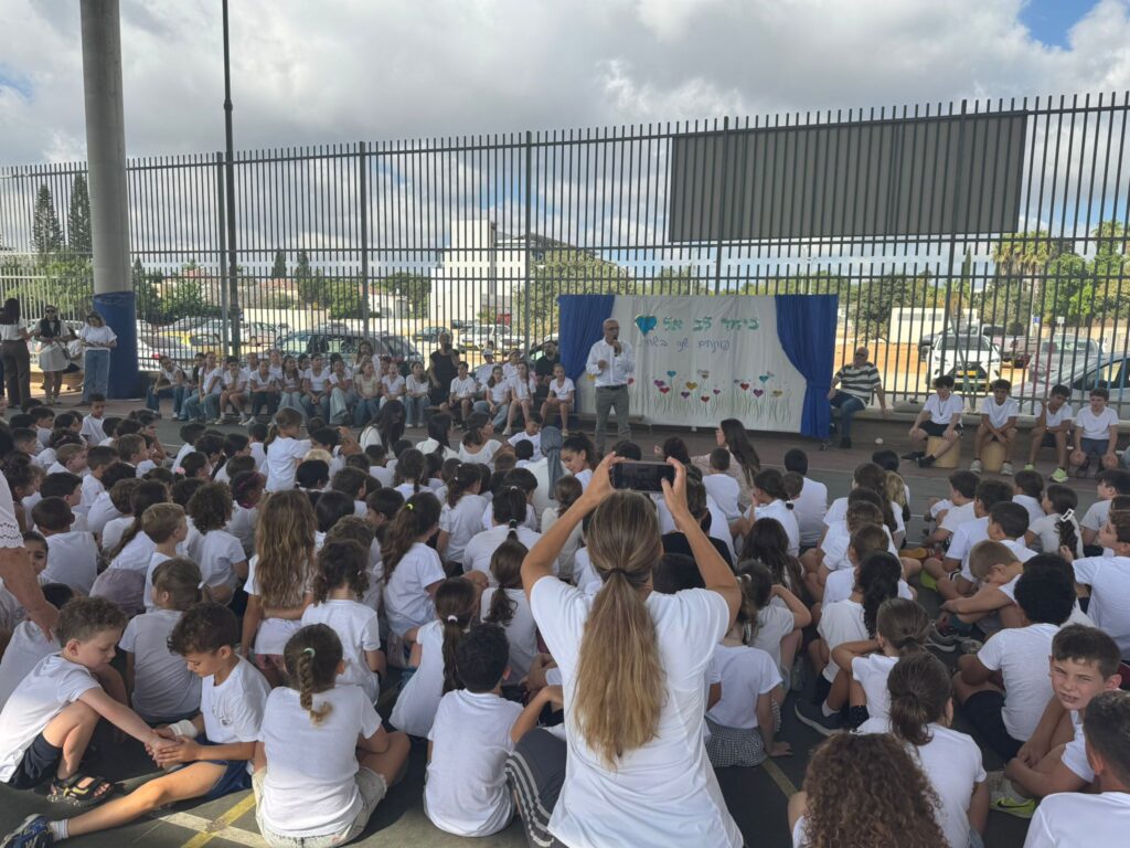 צילום של תלמידים רבים בחצר בית ספר בתחילת שנה