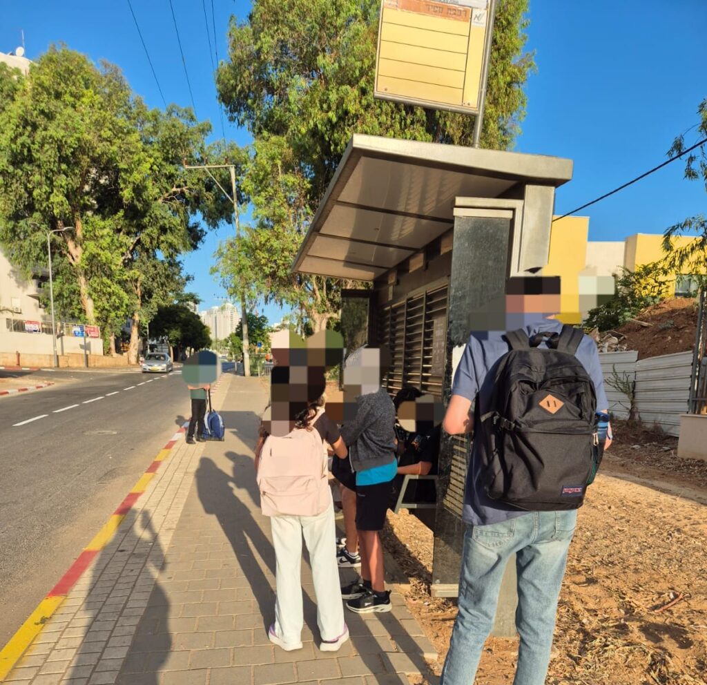 תמונה מטושטשת של ילדים ממתינים בתחנת אוטובוס
