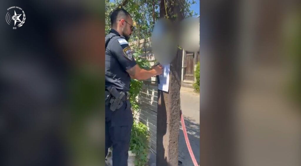 צילום שוטר מצמיד את צו הסגירה מחוץ לאולם האירועים
