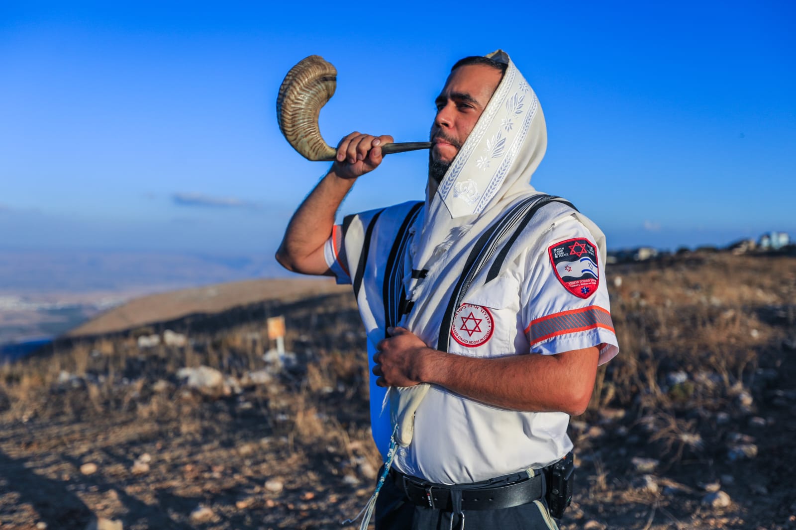 צילום מתנדב מד"א עטוף בתלית תוקע בשופר