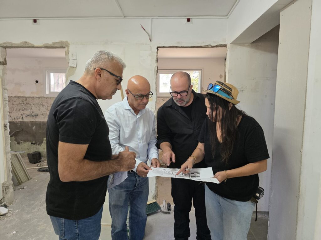 ראש המועצה עם אנשי מקצוע במבנה שמשפצים