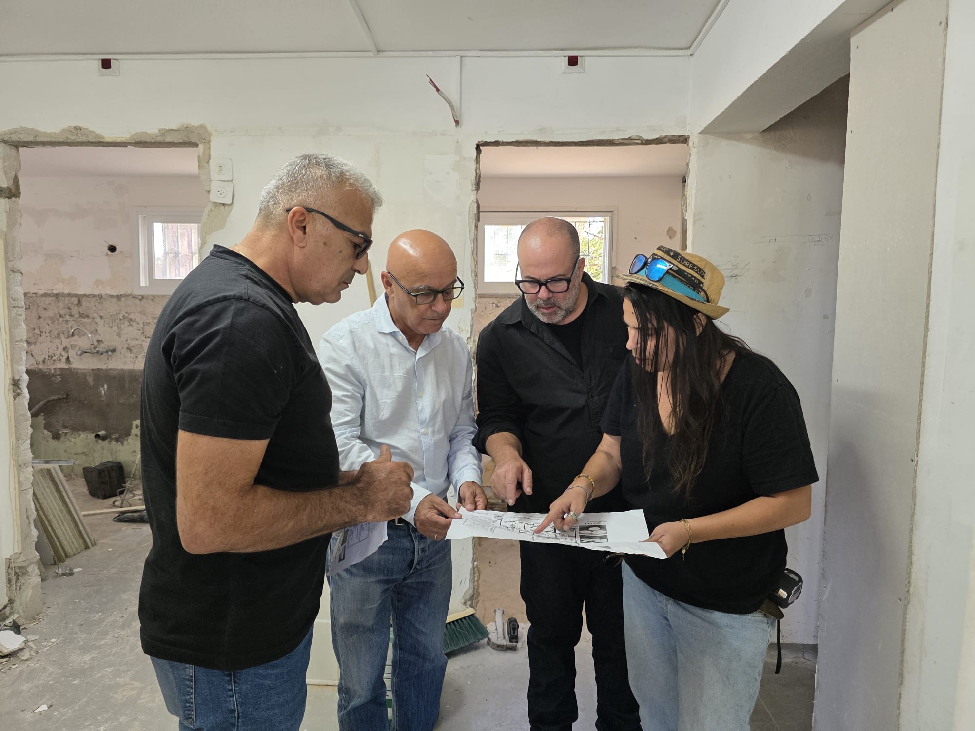 ראש המועצה עם אנשי מקצוע במבנה שמשפצים