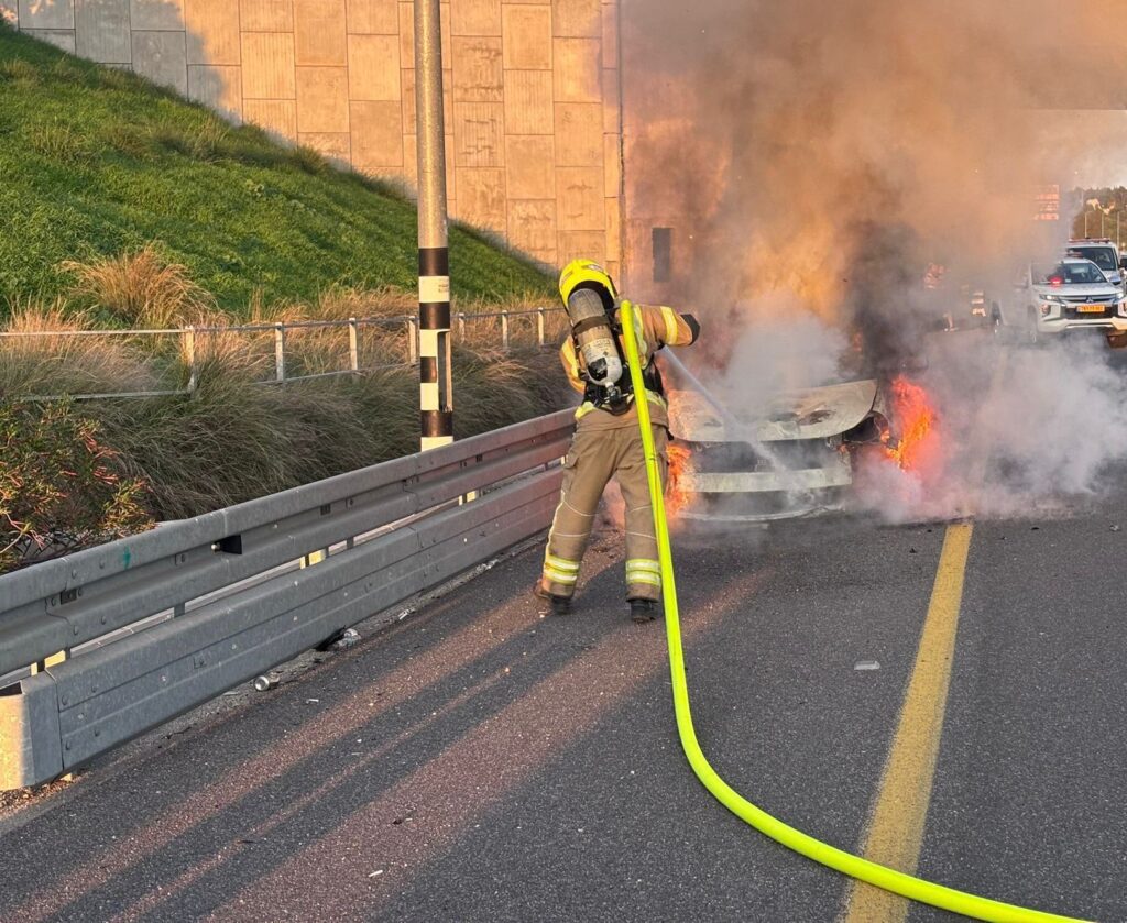 לוחם אש מכבה רכב שרוף