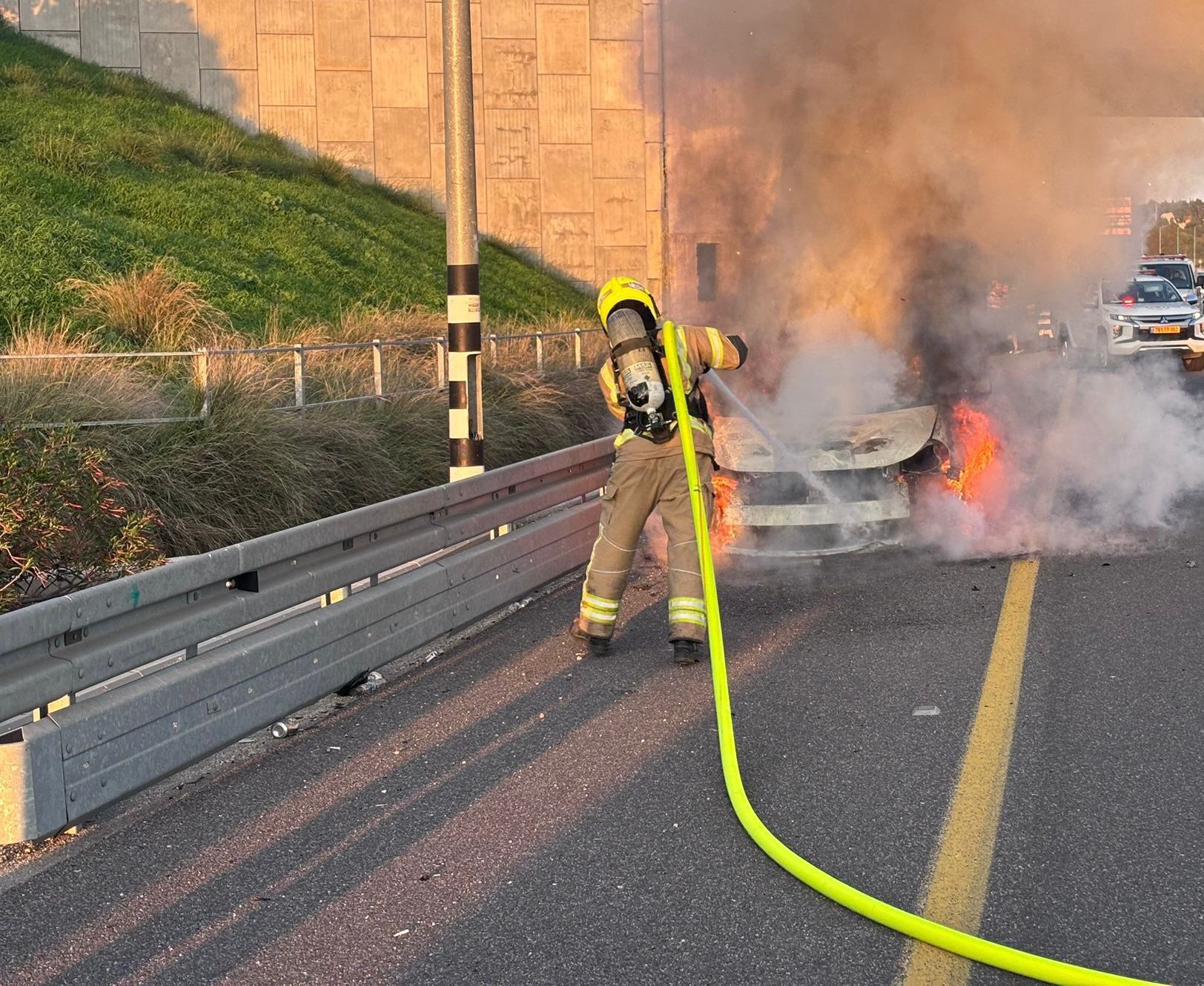 לוחם אש מכבה רכב שרוף
