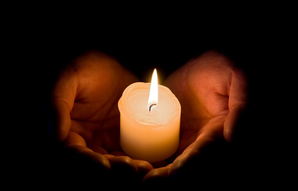 נר דולק בין שתי ידיים